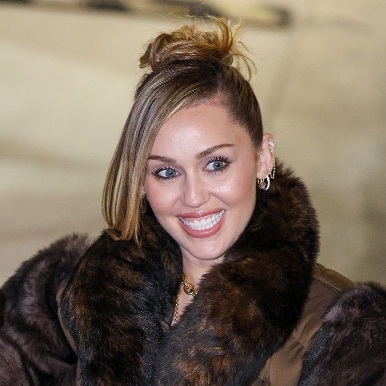 Image may contain: Miley Cyrus, Clothing, Coat, Adult, Person, Fur, Face, Head, Photography, Portrait, and Accessories